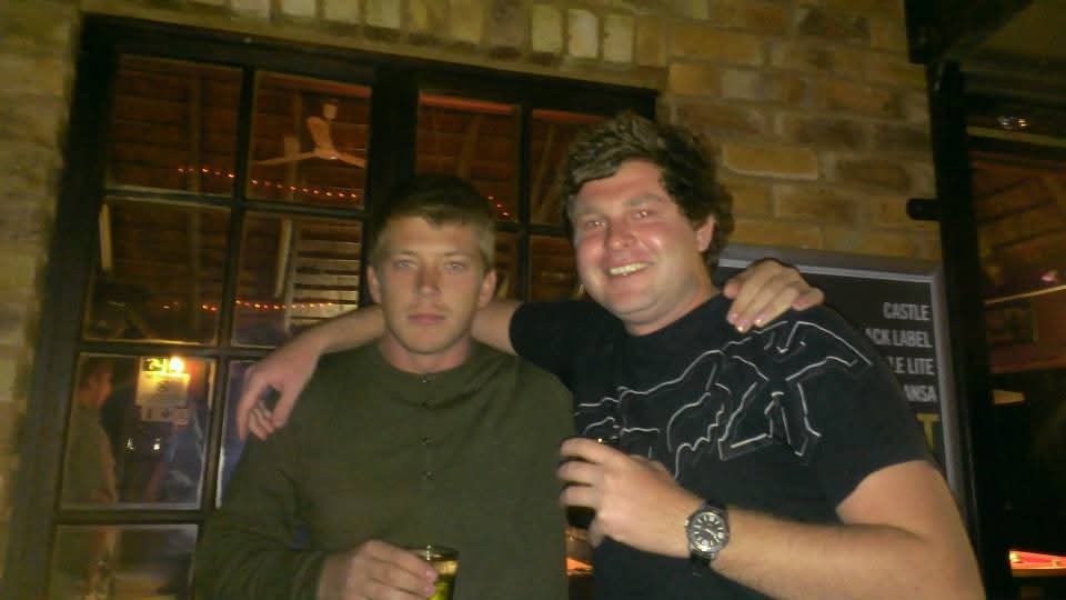Two friends standing together at a pub at night