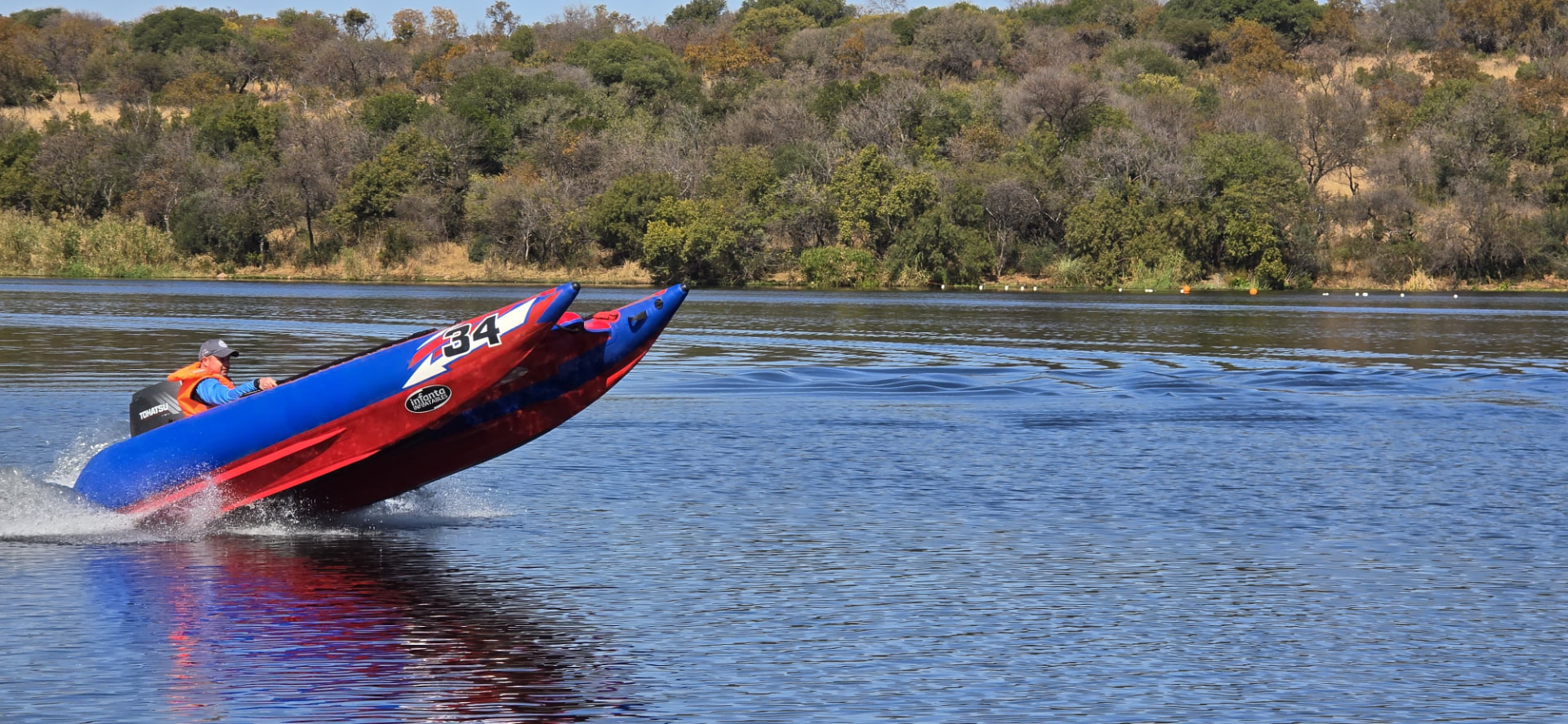 The red-and-blue number 34 boat rising higher with both inflatable bows visible