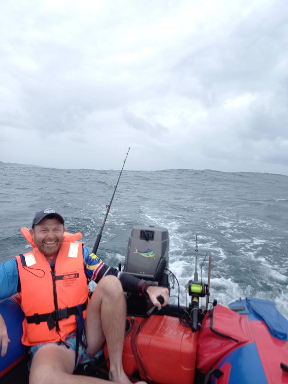 Angelo smiling in a life jacket aboard an inflatable boat at sea