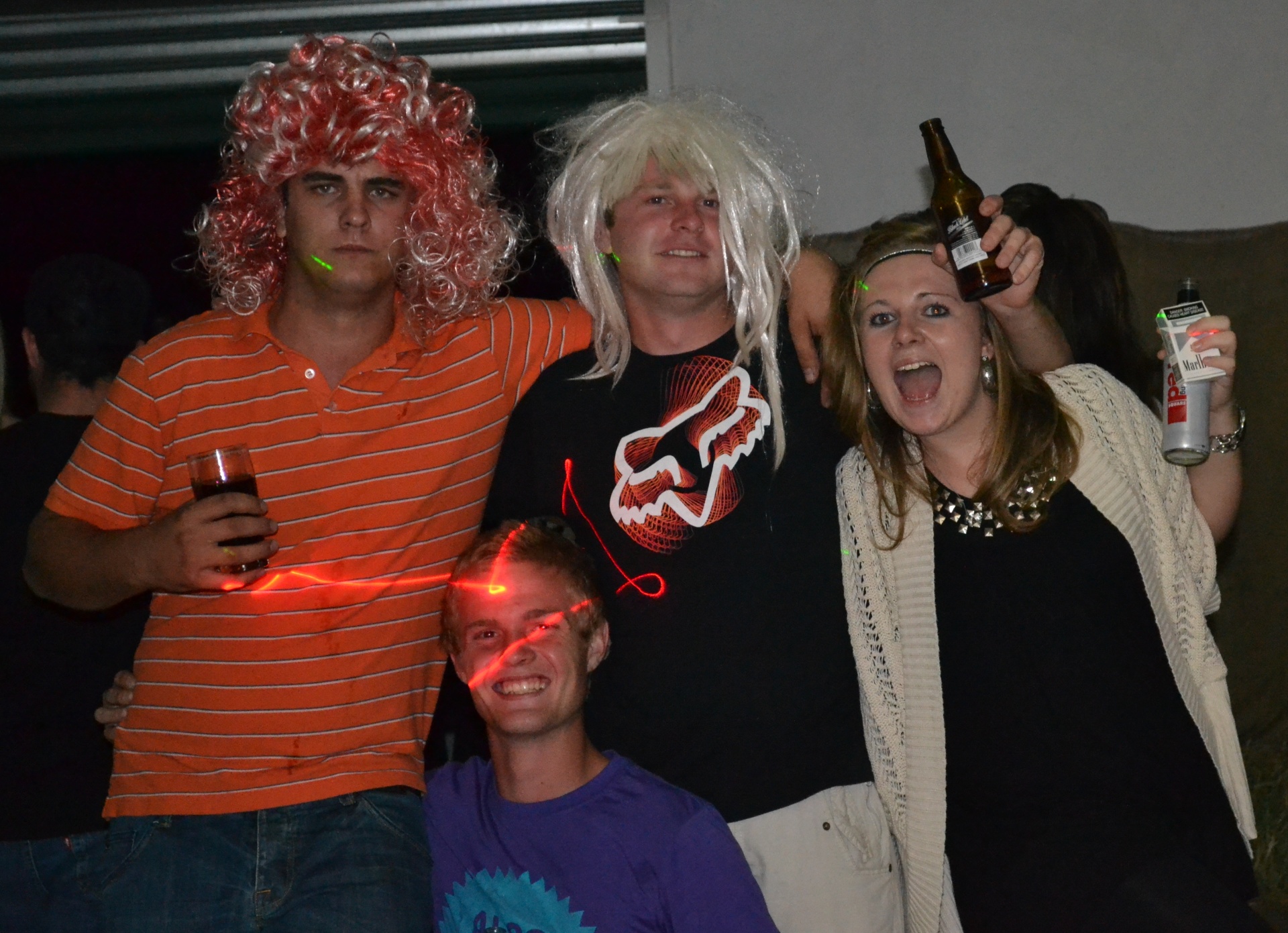 Angelo and friends in fancy-dress wigs at a party