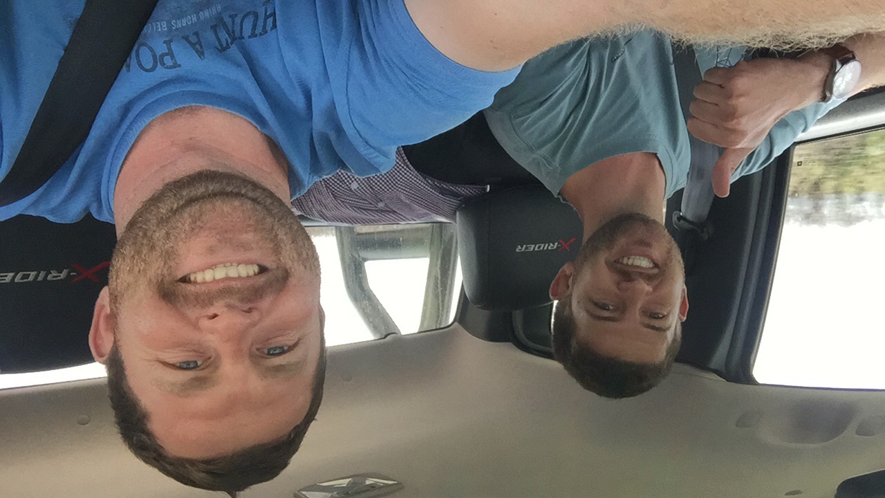 Angelo and Boeljas smiling together inside the bakkie on their trip