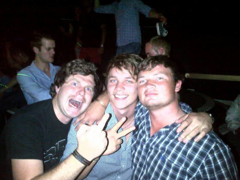 Three friends smiling together on a night out