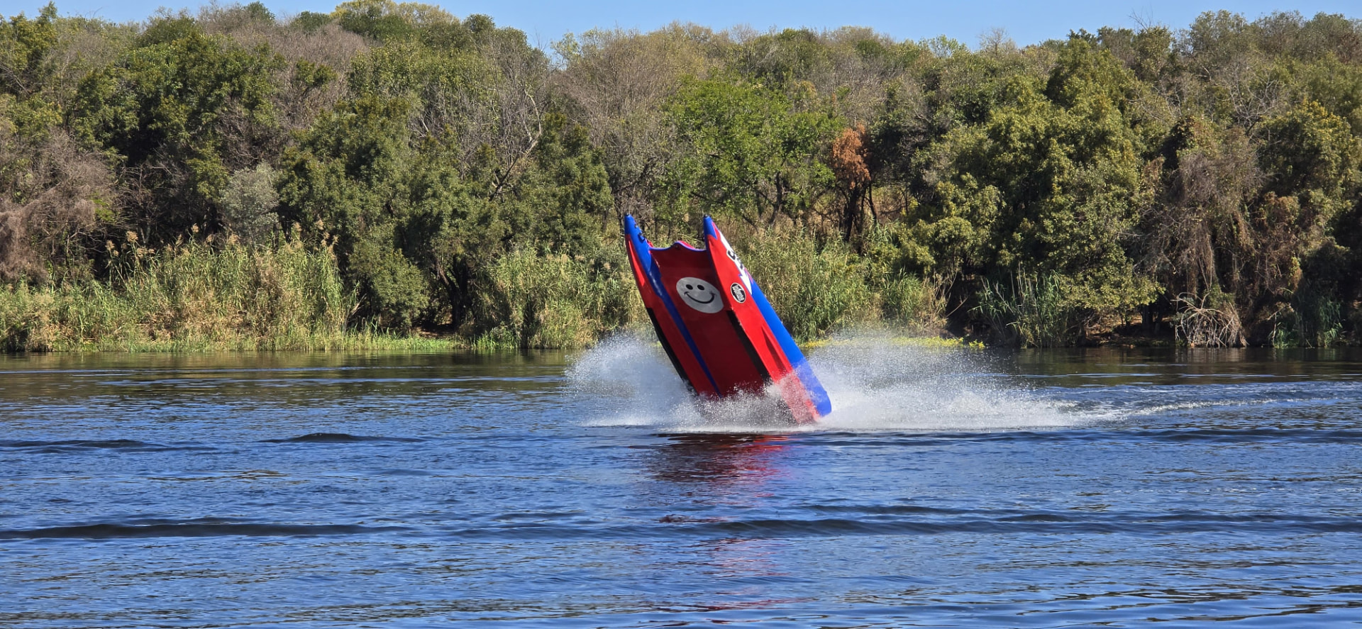 A front view of the raised red-and-blue boat showing the smiley face beneath its bow