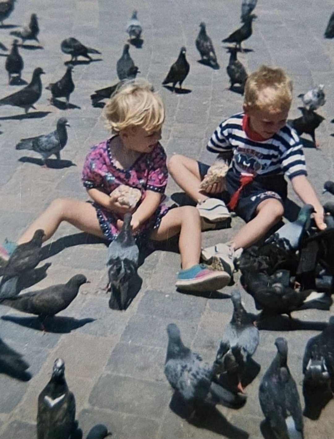 Angelo and his sister as small children feeding pigeons