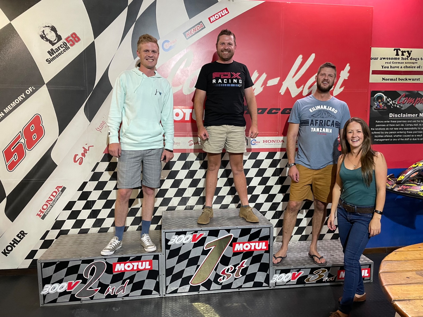 Friends standing on a go-kart winners podium