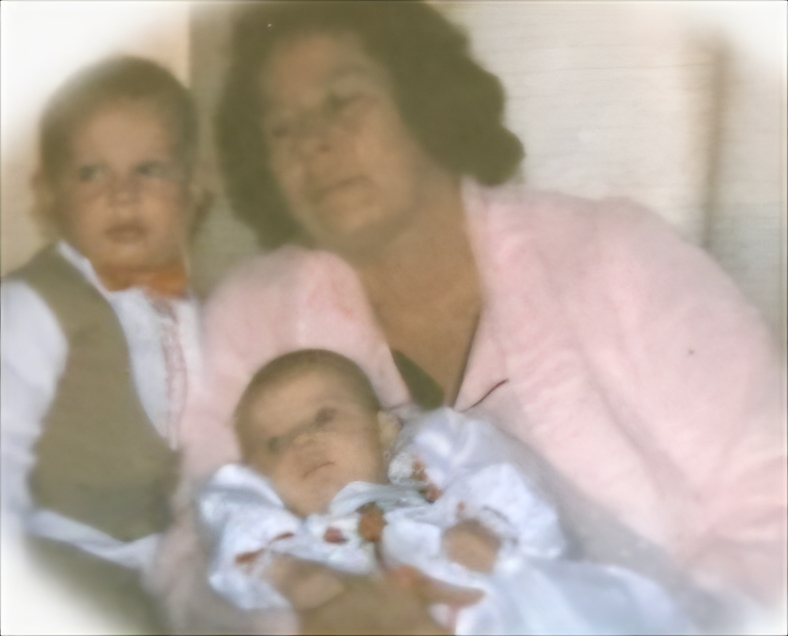 A vintage oval-framed portrait of a grandmother with two children in christening clothes