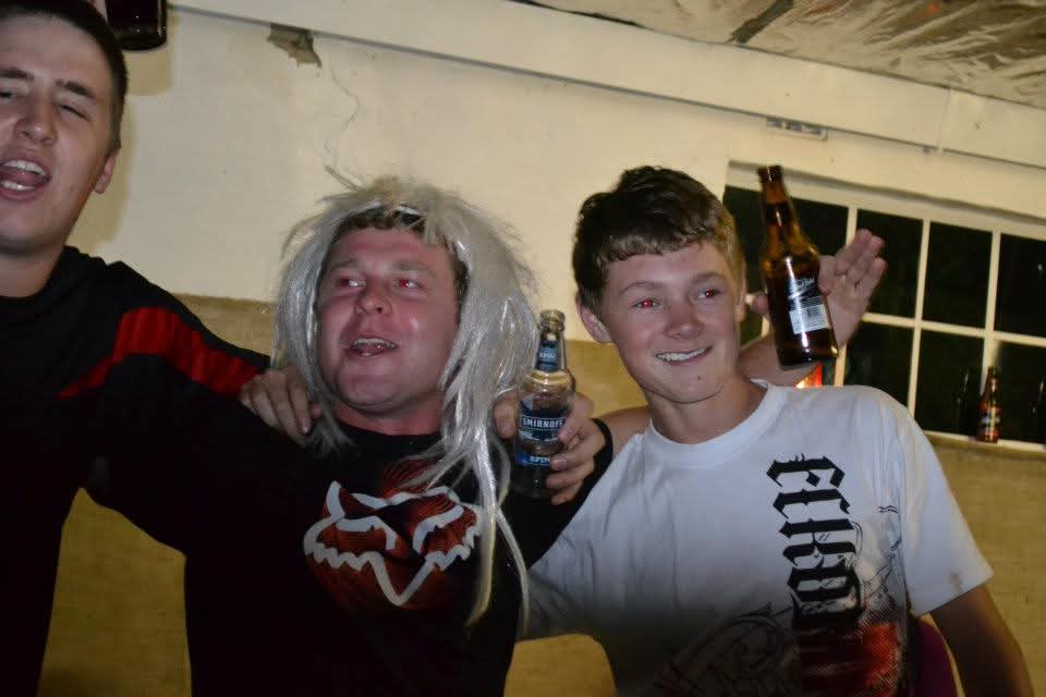 Angelo in a white wig laughing with Dean at the party
