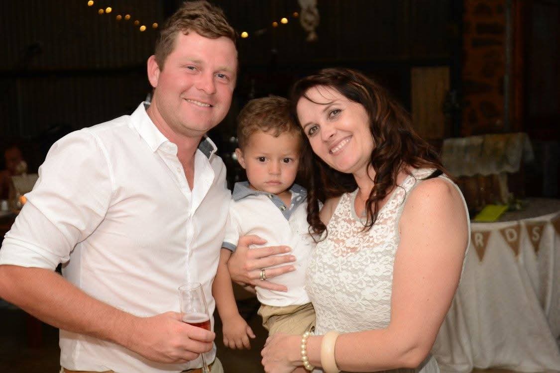 Angelo with a woman and a young child at a family celebration