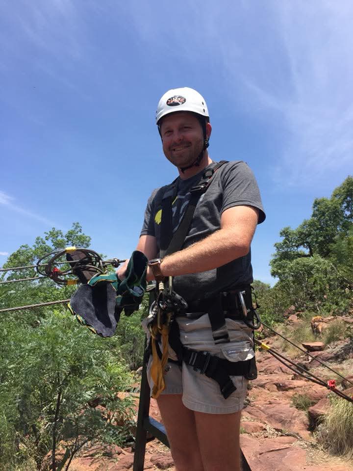 Angelo smiling in his helmet and harness before a zipline ride