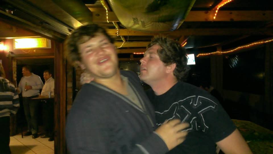Two friends sharing a lively moment indoors at night