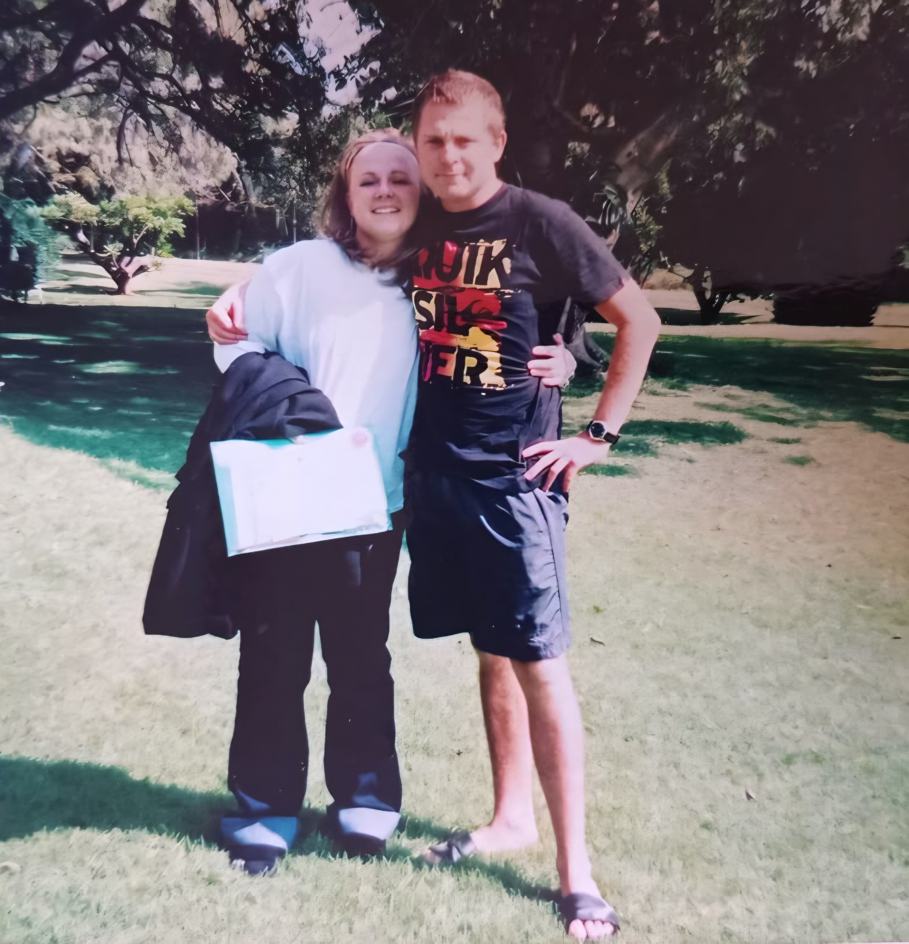 Angelo and his mum posing together outdoors on a sunny day