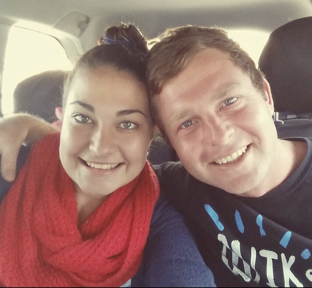 Angelo and a friend smiling cheek to cheek in a car