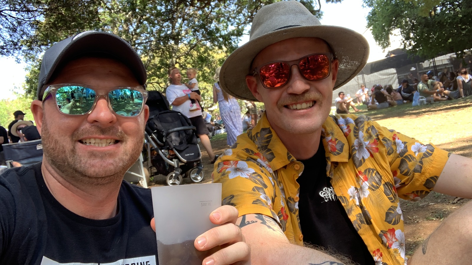 Angelo and a friend taking a selfie at an outdoor festival