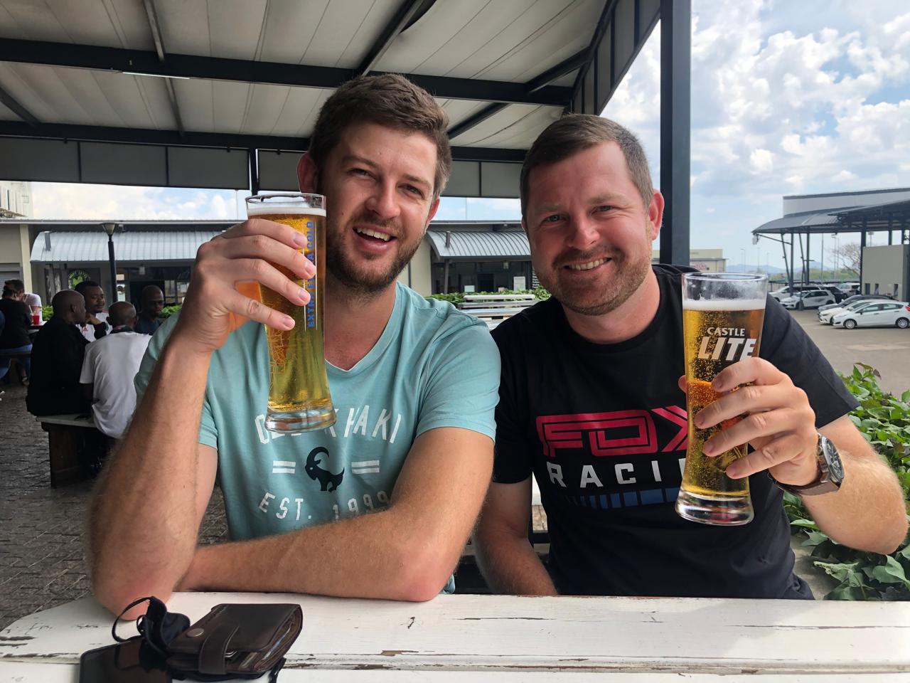 Angelo and a friend raising a glass together at a pub