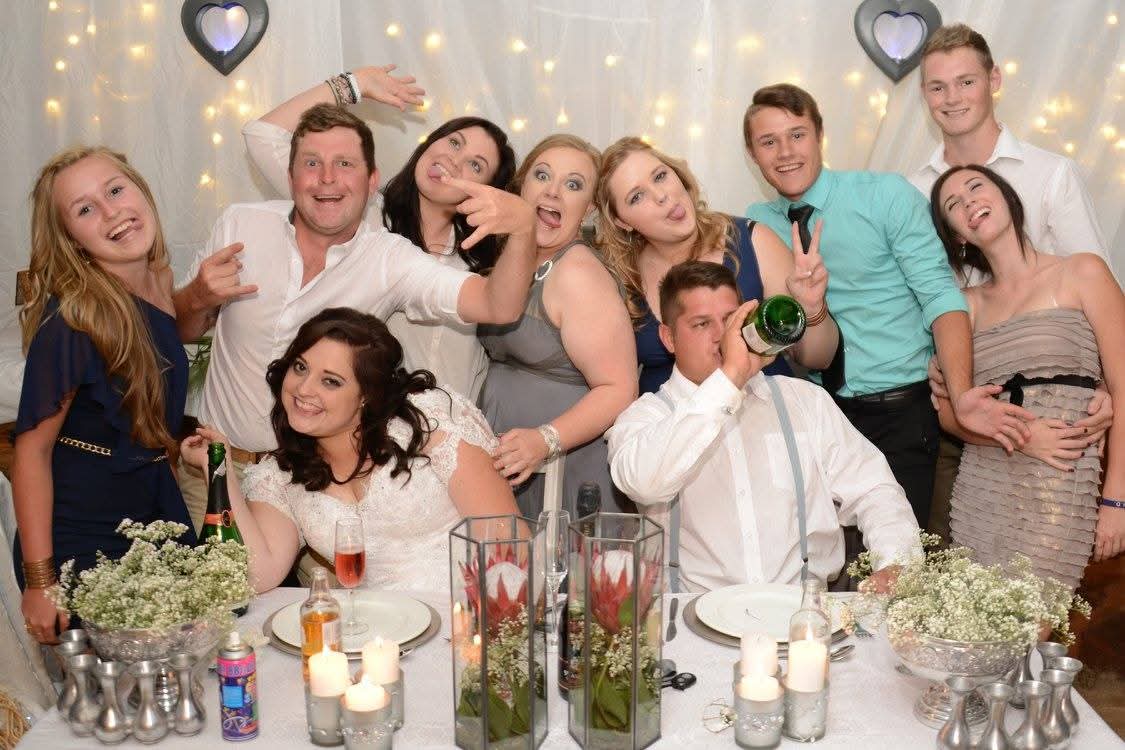 Family and friends posing playfully behind a decorated dinner table