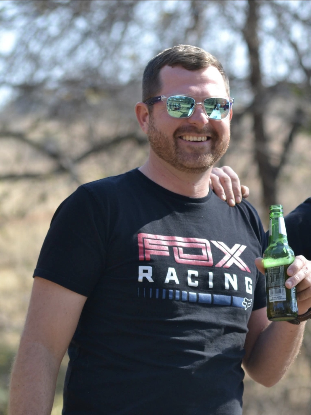 Angelo outdoors wearing reflective sunglasses and a FOX Racing shirt