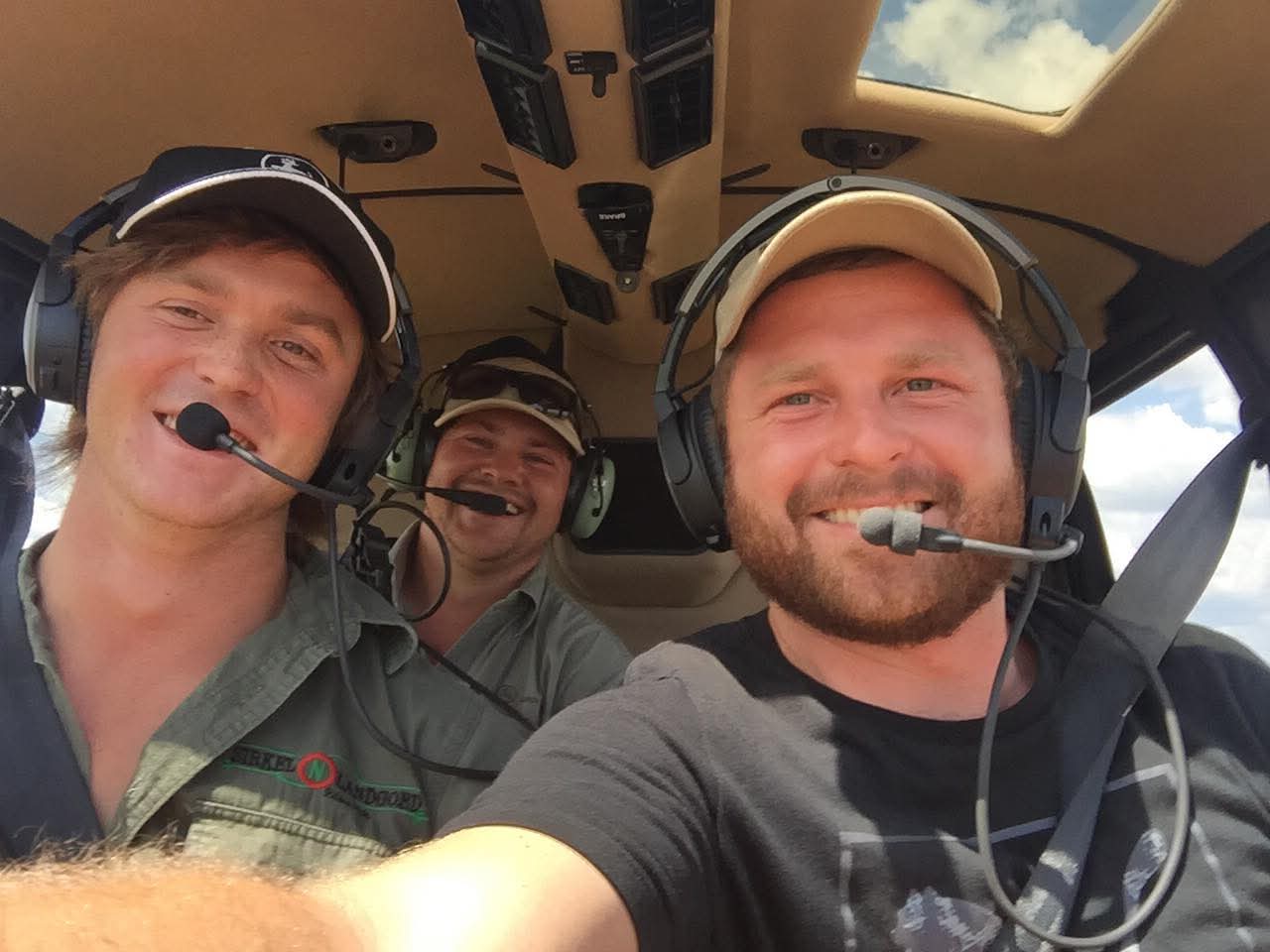Angelo and friends smiling together in a helicopter cockpit