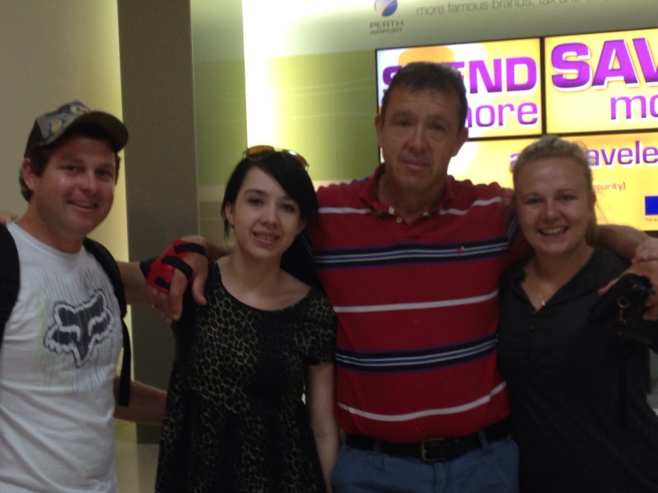 Angelo with family and friends smiling together in an airport arrival hall